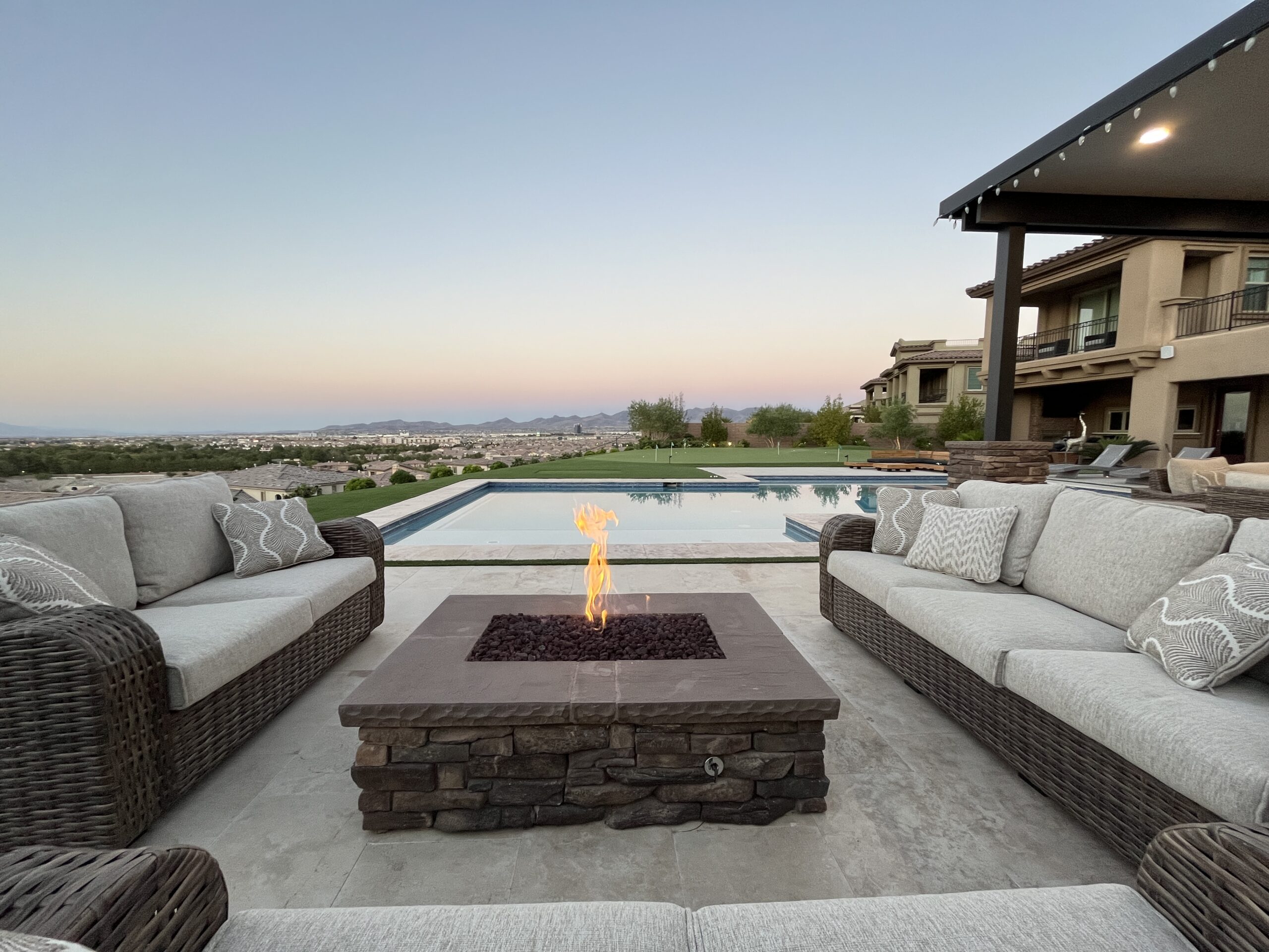 A fire pit sitting next to a pool in the middle of a patio. A fire pit sitting next to a pool in the middle of a patio.